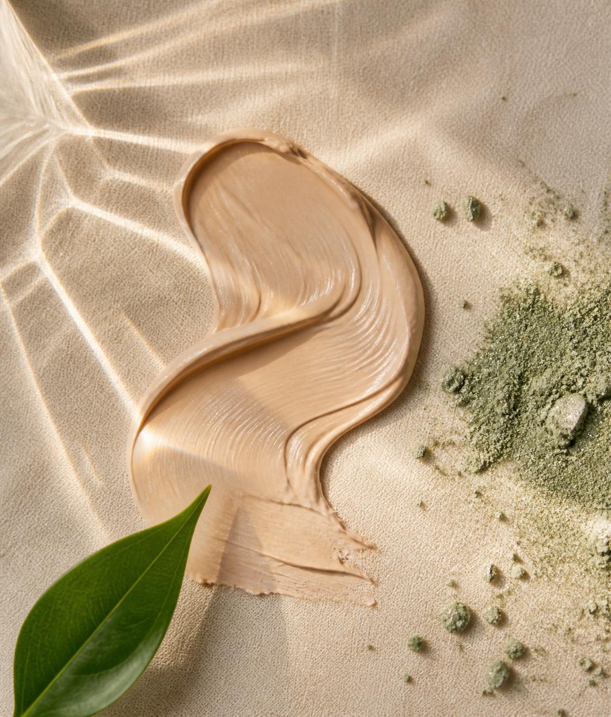 Composição da fórmula: textura cremosa, pigmentos em pó e folha verde sob luz natural